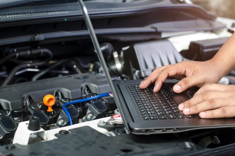 Detail of a mechanic using electrnoic diagnostic equipment to tune a car